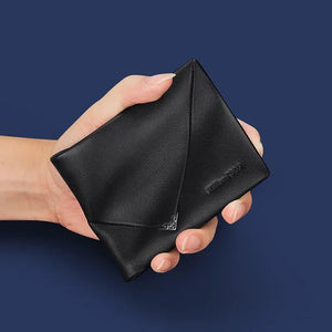 Carteira masculina em couro legítimo preta segurada na mão, mostrando o corte envelope