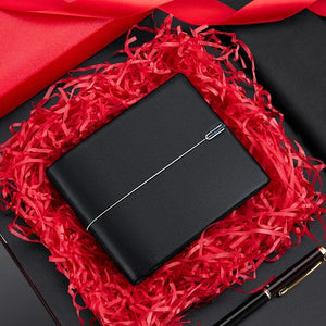 Carteira masculina em couro preta na caixa, com fundo vermelho e caneta