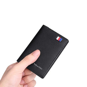 Carteira masculina em couro preta slim com textura saffiano gravada, segurada na mão